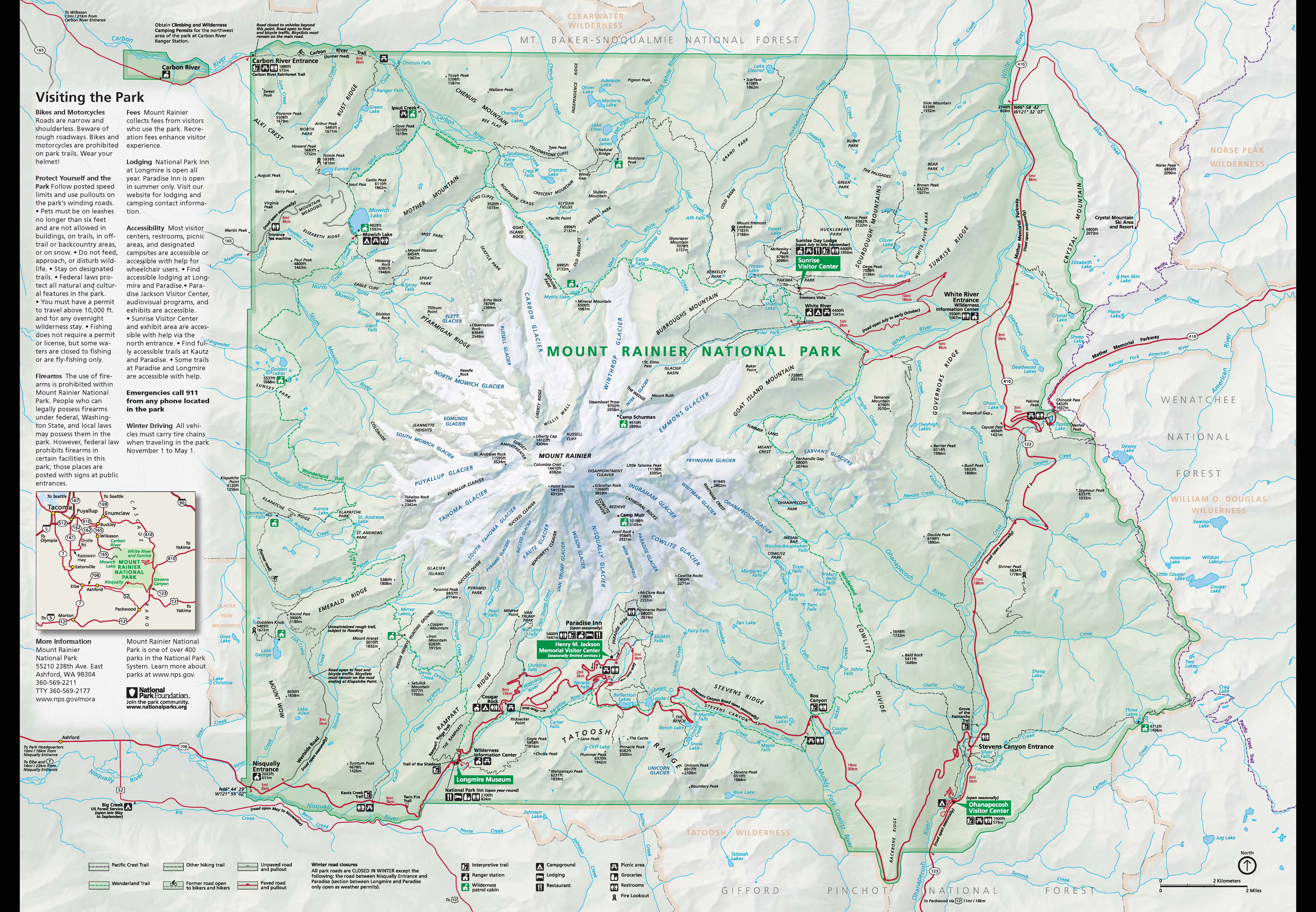 A detailed map of Mount Rainier National Park showing roads, trails, and visitor areas with amenities. The map is focused on the area within the park boundary, with a minimum of information on the areas immediately outside of the park. To the north, the park is bordered by Mt. Baker-Snoqualmie National Forest and the Clearwater Wilderness. Crystal Mountain Ski Area and Resort is outside of the northeast corner of the park. Wenatchee National Forest and the William O. Douglas Wilderness borders the eastern edge of the park. Gifford Pinchot National Forest and the Tatoosh Wilderness wraps around the southern border of the park. The southwest corner and much of the west side of the park is privately owned. The Glacier View Wilderness borders the southern half of the western edge of the park. The park is roughly square, with mostly straight borders on the west, north, and south sides. The east side pushes out slightly with a squiggly border that follows a mountain ridgeline. The center of the park is dominated by Mount Rainier, drawn with white glaciers radiating out from the summit. All roads and trails are around the mountain on the edges of the park. All park land is shaded green. In the northwest corner a small oblong section of land just outside of the main park is also shaded in green. This section surrounds the Carbon River Ranger Station. Moving clockwise around the park, other visitor centers include the Sunrise Visitor Center and White River Ranger Station in the northeast quadrant of the park, the Ohanapecosh Visitor Center in the southeast corner, the Henry M. Jackson Memorial Visitor Center in Paradise in the south, and the Longmire Museum in Longmire to the southwest of Paradise. The following subsections describe in detail the map legend, park amenities, roads and trails, and Mount Rainier's glaciers.